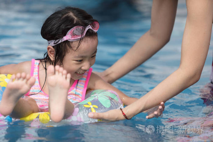 亚洲小中国女孩在游泳池室外玩耍