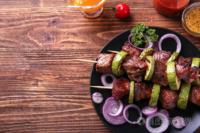烤肉串与多汁肉和蔬菜在板材