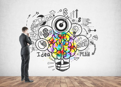 丰富多彩的创意商业理念素描画在一个具体的墙上和思考的侧面视图照片