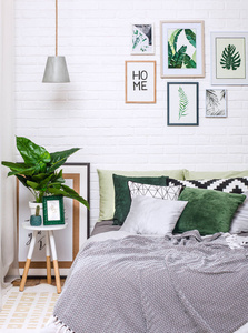 卧室内部灰色绿色色调与图片在白色的墙壁垂直