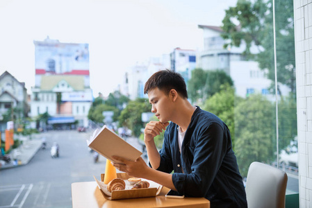 在一家咖啡店看书的人