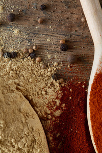 在木桶背景上, paprica 和黑胡椒木勺的顶部视图, 选择性聚焦