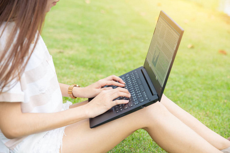 亚洲大学女孩青少年学生使用笔记本电脑在公园工作讲座