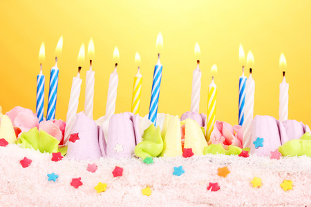 在黄色背景上的蜡烛的生日蛋糕