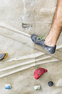 在室内人工墙上练习攀岩的人。积极的生活方式和抱石赛的理念
