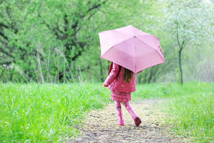 孩子用粉红色的雨伞户外散步的女孩