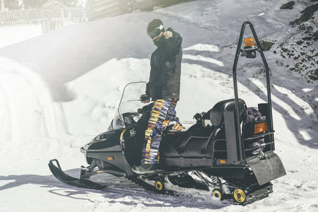 胡子 snowboarded 中毒在雪地车上。雪地巡逻队背景模糊。水平. 视觉效果