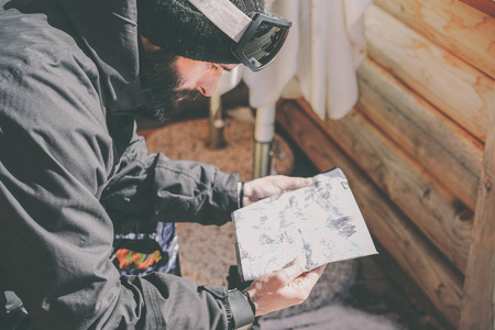 长胡子英俊的 snowboarded 休息后, 乘坐会议。年轻人看着阳光露台的山图。背景模糊。水平