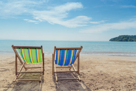 两个沙滩椅上的白色沙滩上, 蓝天和夏季海背景。暑假度假旅游和度假概念