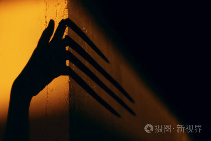 可怕的阴影.抽象背景.墙上一只大手的黑色影子.墙上一只手的剪影.
