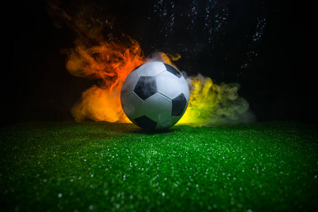 足球赛场上的传统足球。在绿色草地上的足球 足球 的特写视图深色色调的雾背景