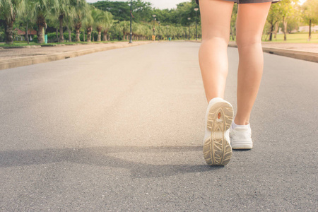 在公共公园的混凝土步道上奔跑的女子腿