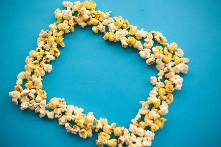 食品。冷冻爆米花玉米美味的黄色爆米花在蓝色的背景。电影院。Copyspace。文本位置