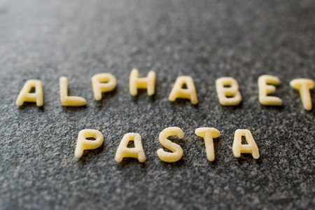 原始的字母意大利面是写在 Granit 灰色表面上的字母。未煮的有机食品