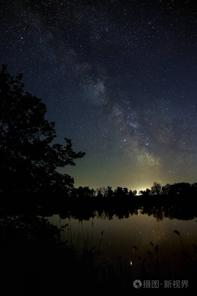 夜空中有星星的空间.与河和树的风景被拍照在长的曝光