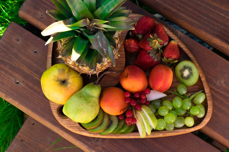 在深色木桌上混合不同异国情调的新鲜多彩水果
