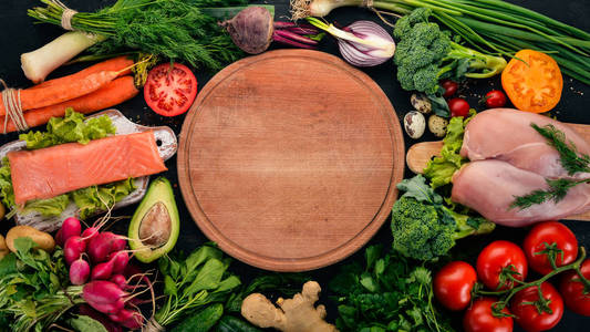 健康食品。鱼肉和蔬菜。在一个黑暗的木质背景。顶部视图。复制空间