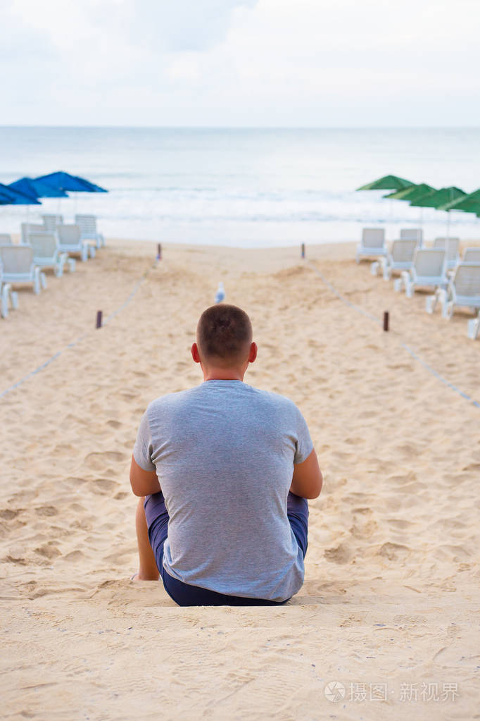 年轻男人与他的背坐在沙滩上照片-正版商用图片050e2z-摄图新视界