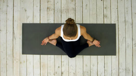 交叉的腿运动年轻漂亮的女人练瑜伽,交叉腿的姿势坐着照片