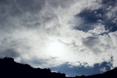 多云的天空背景。太阳是 hiing 中间的框架和云彩