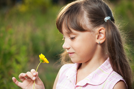 可爱的小女孩玩一朵花