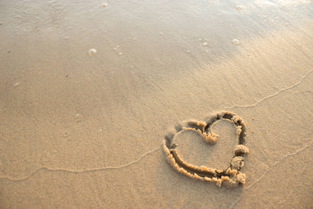 沙滩上的沙滩上的心象征。爱海洋概念