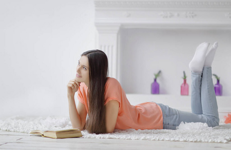 客厅地板上的年轻女孩读书画像