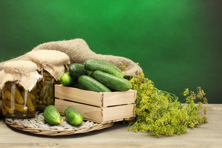 新鲜黄瓜在木盒 泡菜和莳萝，绿色背景