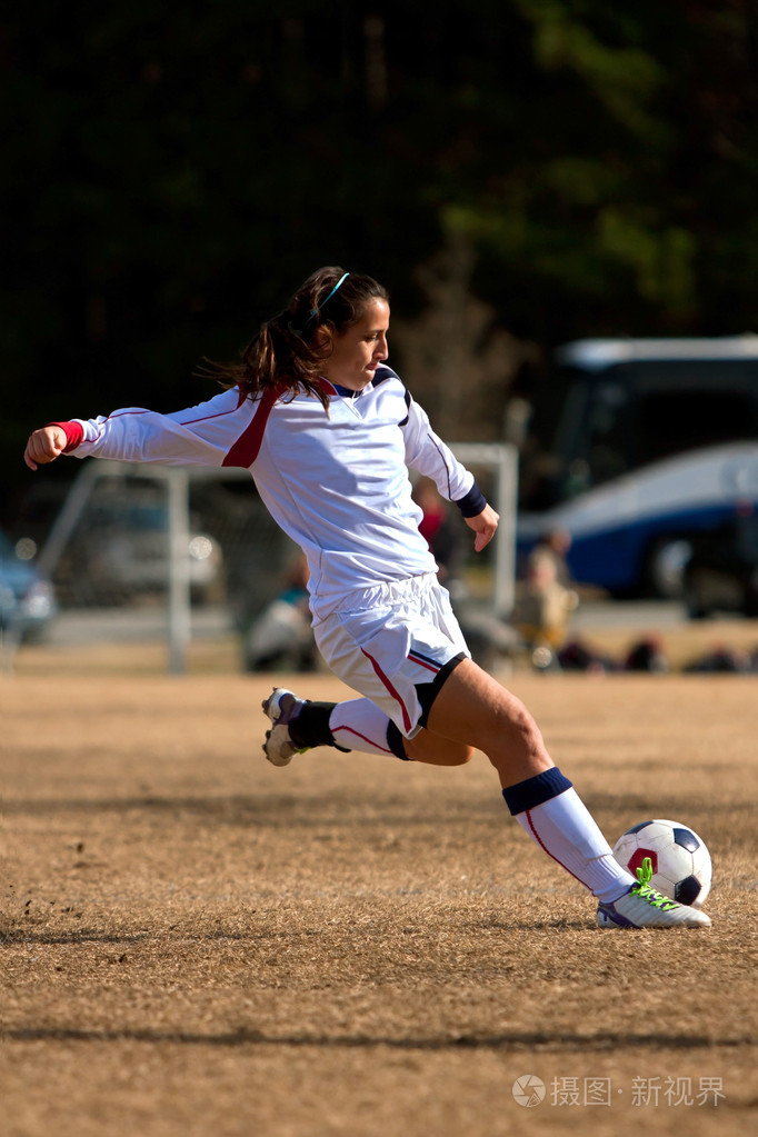 女子足球球员准备要把球踢在比赛期间