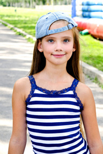 可爱的快乐微笑的小女孩与滑板户外在夏天的一天