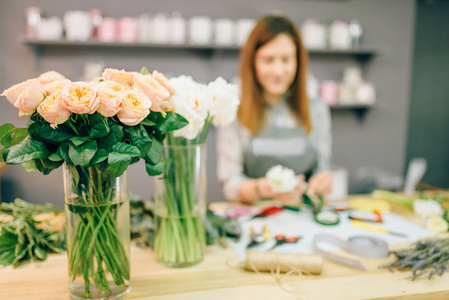 女花商在工作场所准备玫瑰花束。花卉店, 花卉业务