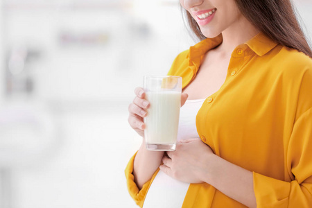 美丽的孕妇在家喝牛奶