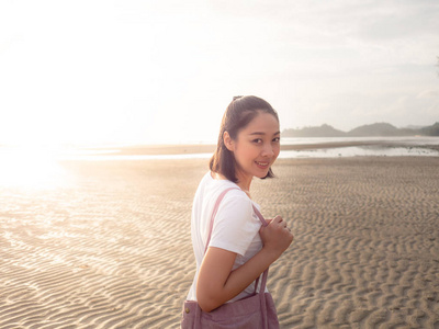 亚洲妇女在日落热带海滩漫步