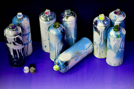 仍然生活与大量使用的彩色喷雾罐的气溶胶油漆躺在处理的木表面在艺术