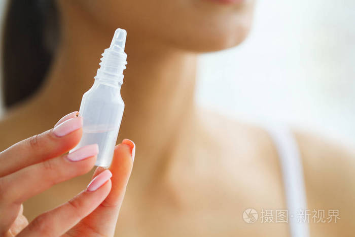 视觉和医学概念小女孩手里拿着眼药水一个美丽的女人与绿色的眼睛和