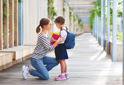 在学校的第一天。母亲带领一个小孩子学校女孩在第一个毕业生