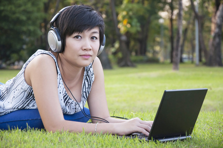 在公园里漂亮的亚洲女人听音乐