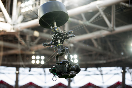 电视摄像机悬挂在足球或音乐会的电缆上