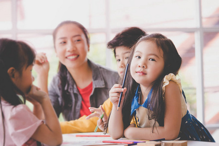 亚洲女孩在幼儿园美术教室画画图片