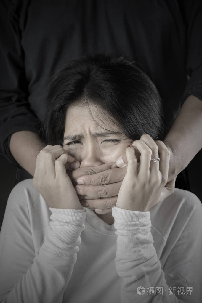 被绑架的妇女的形象看起来沮丧与她的嘴盖由未知的人的手