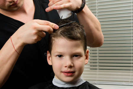 理发师为男孩理发, 并应用一种简单的梳理疗法。