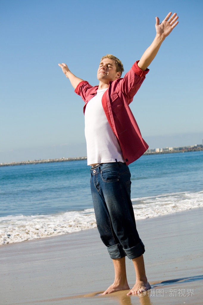 在海滩上伸胳膊雄伟男人