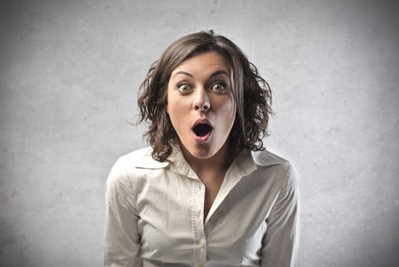 女人正在惊讶地拿着她的脸惊讶的金发女人俯视着眼镜啊.