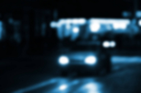 道路上的交通模糊的夜间场面。弥散的汽车与发光的车灯行驶的形象。散景艺术
