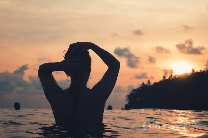 从后面的印度洋的年轻女子洗澡, 抱着她