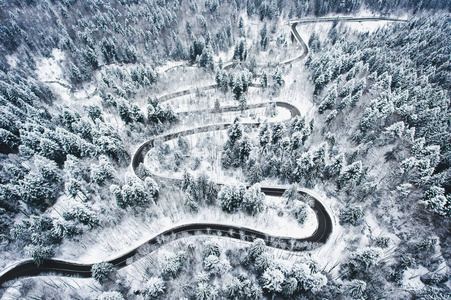 冰雪覆盖的森林中的冬曲蜿蜒道路