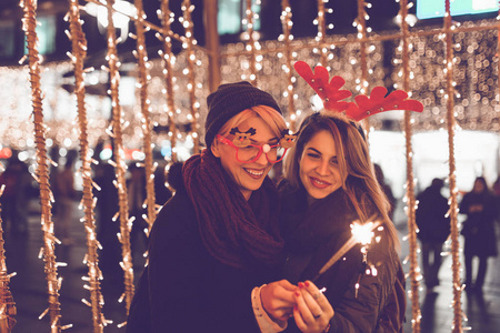 美丽的年轻妇女在城市街道上享受圣诞节或新年夜