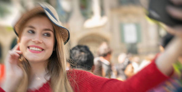 快乐美丽的金发女孩访问巴塞罗那和做自拍。旅游和假日概念