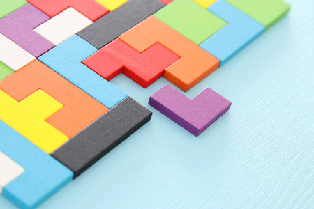 一个五颜六色的正方形七巧板拼图, 在木桌上照片