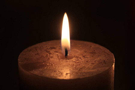 一个大燃烧的蜡烛特写镜头, 深色